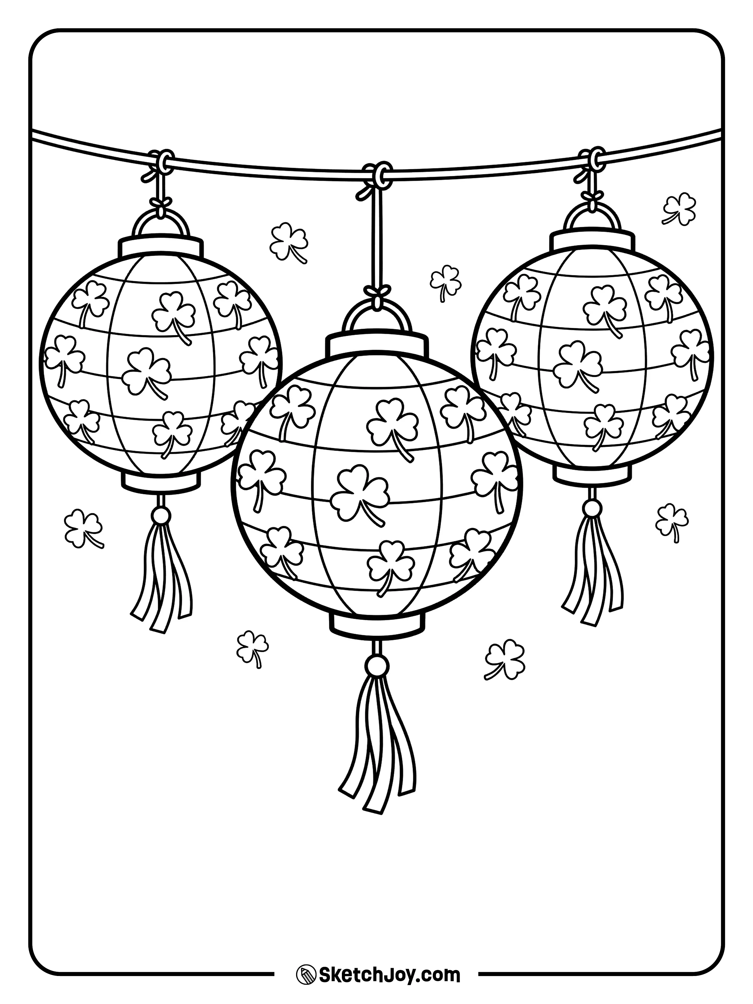 Paper lanterns with shamrock cut-outs hanging from a string.
